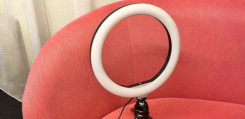 A photo of a ring light on a pink sofa. 